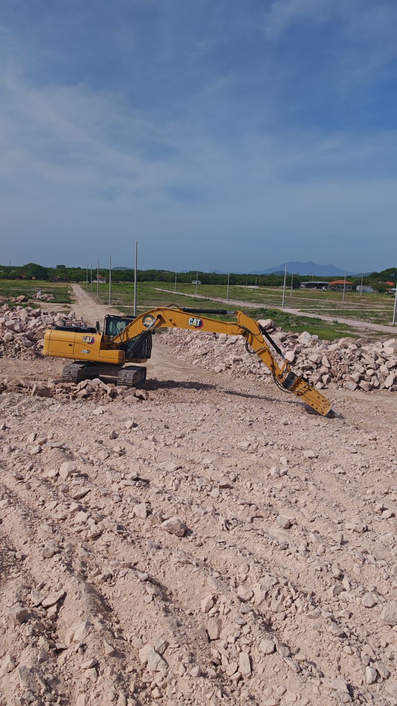 Excavadora con martillo hidráulico rompiendo piedra